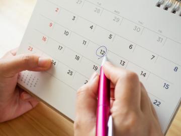 Mujer anotando las fechas fértiles en un calendario